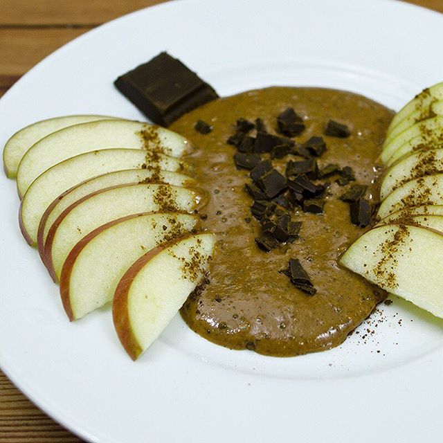 Apple slices with dark chocolate and almond butter on a plate - organicfair.com